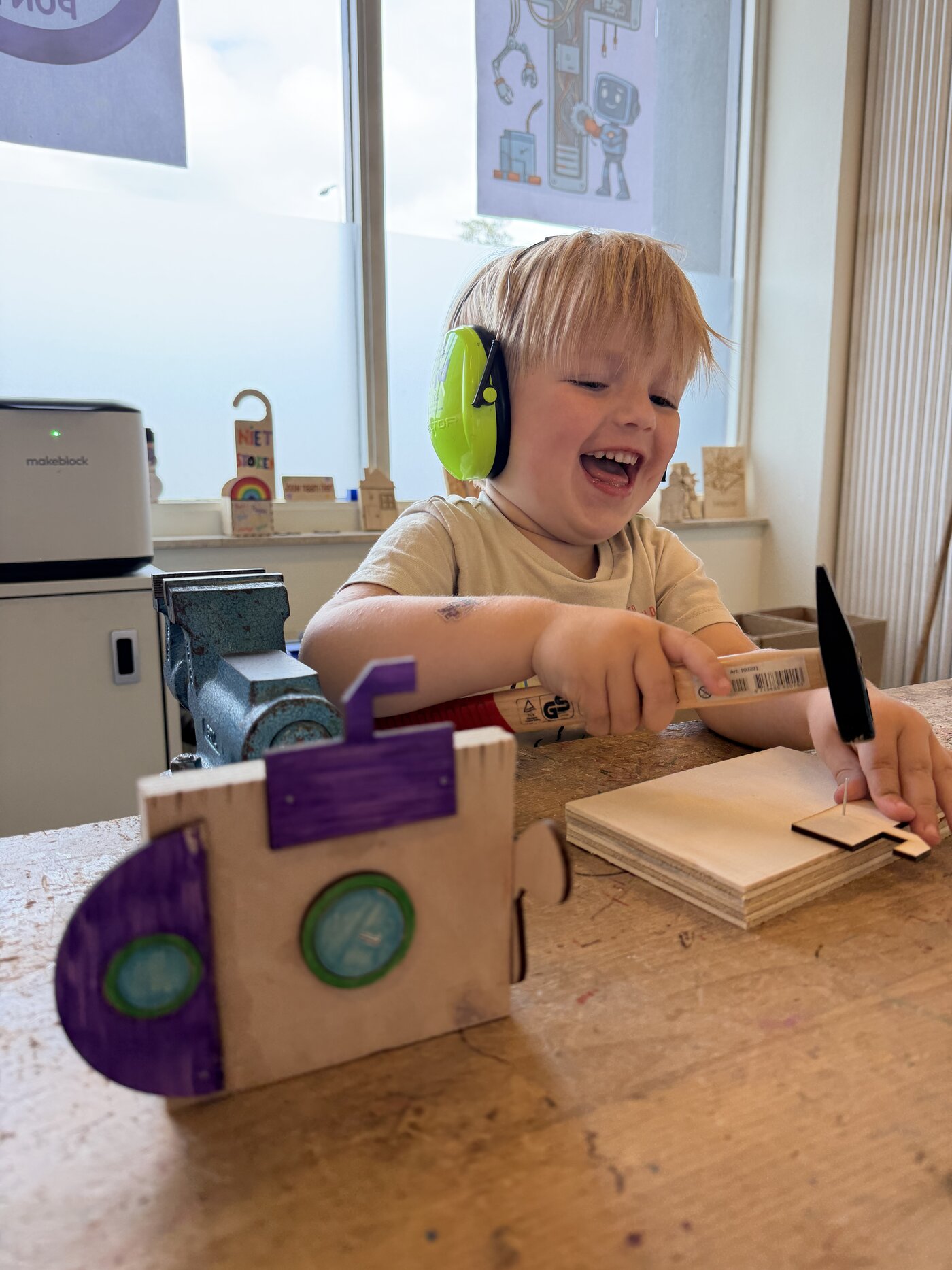Kind hamert een houten trein in elkaar